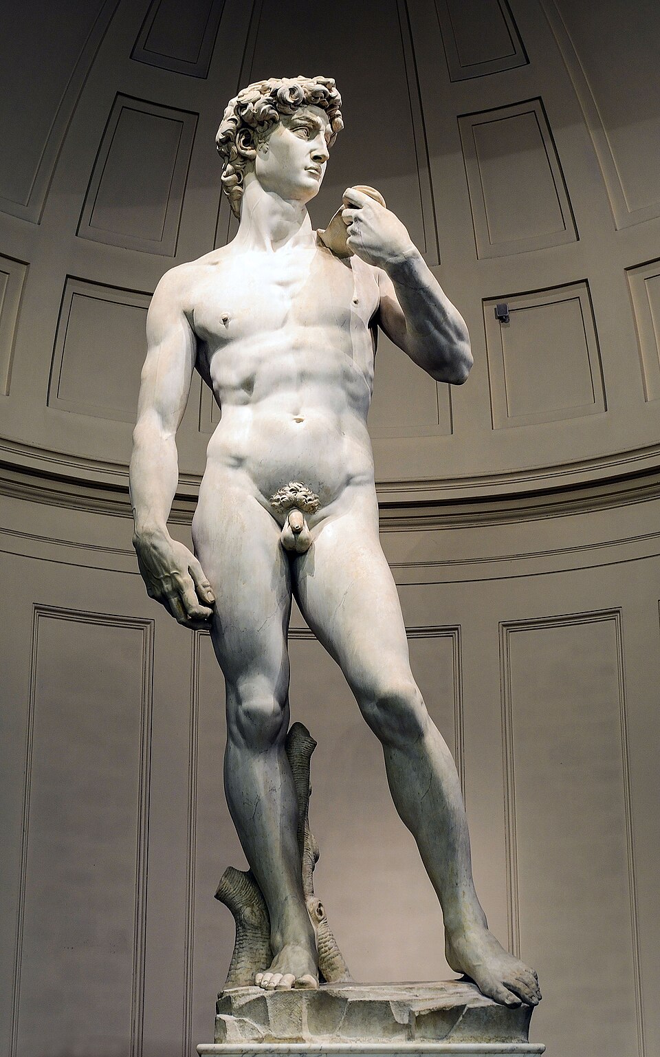Michelangelo's marble statue of David, standing with a sling over his shoulder