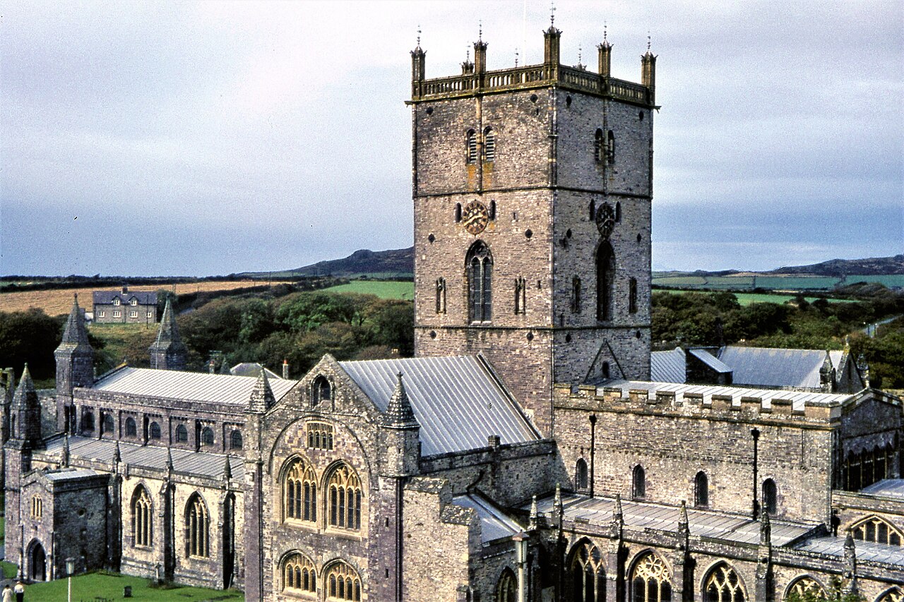 St Davids Cathedral, a long stone church with a square tower, in a green valley